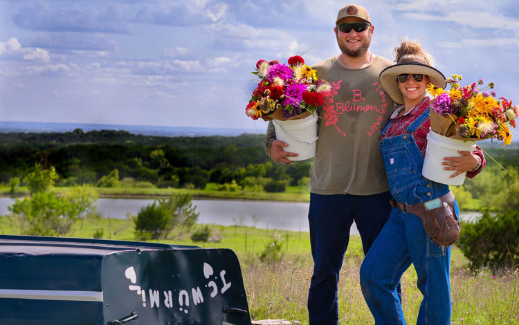 Man and woman with bucket of flowers.